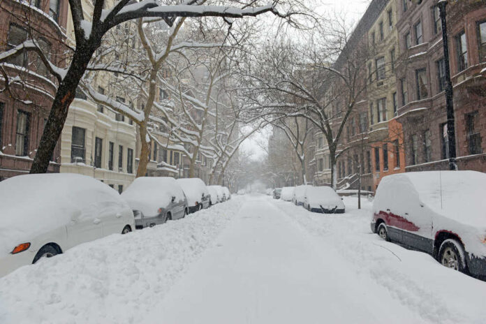 Snow,Covered,Street,And,Brownstone,Buildings,During,Snowstorm,In,Manhattan,