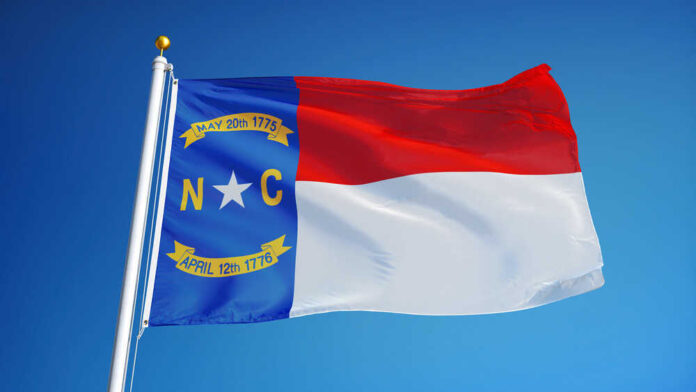 North,Carolina,(u.s.,State),Flag,Waving,Against,Clear,Blue,Sky,