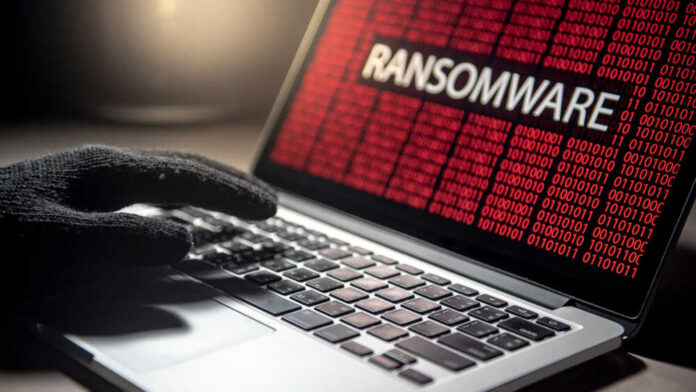 Male,Hacker,Hand,On,Laptop,Computer,Keyboard,With,Red,Binary